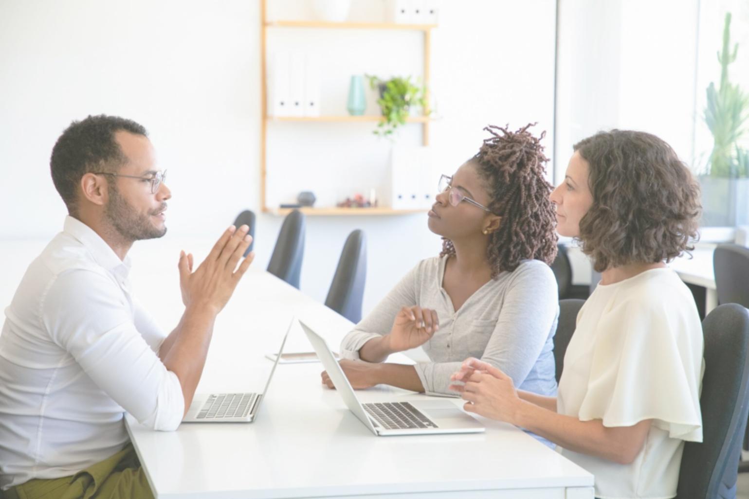 Business meeting with financial charts and analysis documents spread on conference table